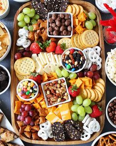 a platter filled with different types of cheeses, crackers and fruit on top of it