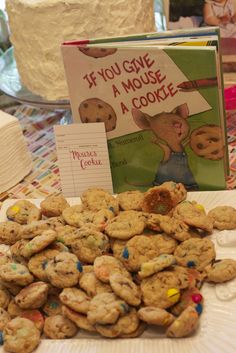 a table topped with cookies next to a cake and a sign that says if you give a mouse a cookie