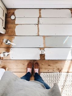 someone's feet and shoes are standing in front of white paint on the wall