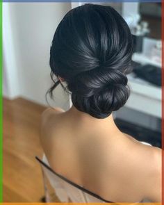 the back of a woman's head, with her hair in a low bun