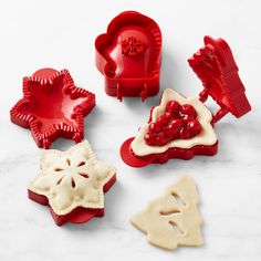 four cookie cutters with different shapes and designs in them on a marble countertop