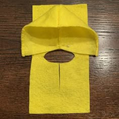 a piece of yellow material sitting on top of a wooden table