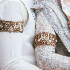 a close up view of two rings on the back of a bride's dress