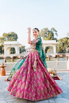 The bridal Lehenga Choli and Dupatta Dress for Wedding has an alluring blend of pink and green shades and it wins everyone's hearts at the very first glance with its charm and elegance. Lavish embroidery and embellishments make this Lehenga Dress an epitome of beauty. Bridal Choli: The choli in premium raw silk is fully emblazoned with lavish designs and fine details of embroidery. Goldwork and perfect stitching make this choli in an alluring green shade a perfect choice to pair with the Lehenga Pink Anarkali Gown For Ceremony, Ceremonial Pink Gown With Zari Work, Green Ceremony Dress With Dupatta, Ceremonial Green Dress With Dupatta, Pink Embroidered Gown For Ceremony, Pink Gown With Intricate Embroidery For Ceremony, Pink Dupatta Gown For Traditional Ceremonies, Pink Anarkali Dress For Ceremony, Pink Sharara With Zari Work For Ceremonies