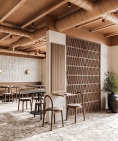 an empty restaurant with tables and chairs in the center, along with wooden partitions on the walls