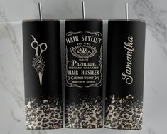 three black and white canisters with hair stylist labels on them sitting on a marble surface