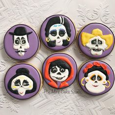 six decorated cookies with sugar skulls and faces in the shape of people's heads