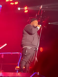 a man standing on top of a stage holding a microphone