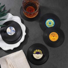 four black records sitting on top of a table next to a cup and saucer