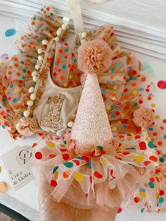 two hats are sitting on a table with confetti around them and one hat is pink