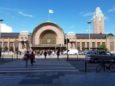 people crossing the street in front of a large building