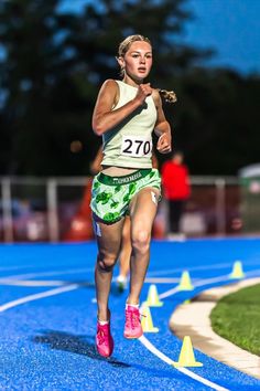 a woman running on a blue track at night