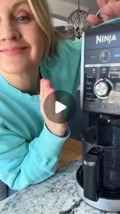 a woman standing next to a coffee maker