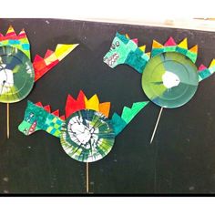 three paper plates with dinosaurs on them and one is made out of construction paper, the other has scissors