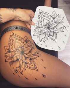 a woman's thigh with tattoos on it and a flower tattoo design on the side