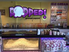 popcorn is being served in front of the poppedi counter at an ice cream shop