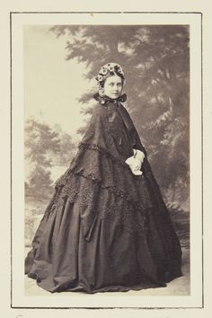 an old black and white photo of a woman in a dress