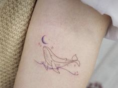 a woman's arm with a tattoo on it that has a whale in the water