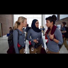 two women talking to each other in a hallway