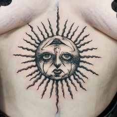 a woman's chest with a sun tattoo on it