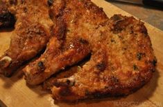 two pieces of meat sitting on top of a wooden cutting board