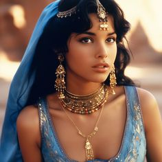 a woman in a blue dress with gold jewelry on her neck and headdress