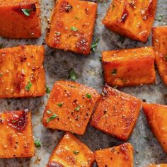 cooked sweet potatoes on a baking sheet with herbs