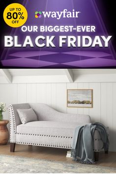 a white couch sitting on top of a wooden floor next to a purple and black sign