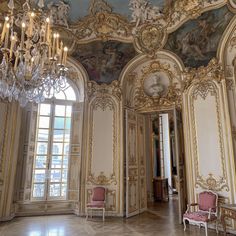 an ornate room with chandeliers and paintings on the walls