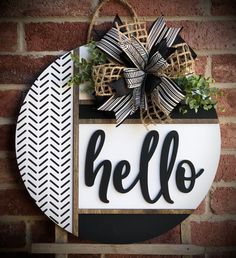 a black and white sign that says hello with a bow hanging on the side of it