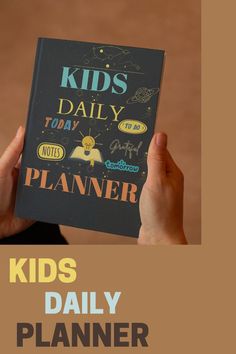 a person holding up a book with the title kids daily planner