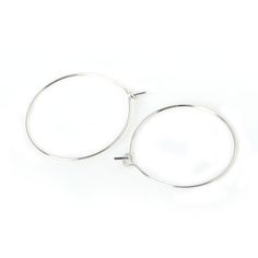 pair of silver hoop earrings on white background with clipping for use in jewelry design