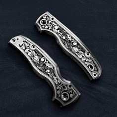 two ornate metal handles on a black surface