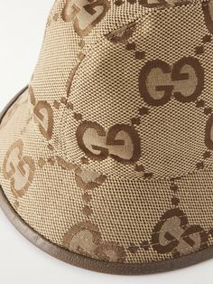 Gucci's bucket hat is printed with a jumbo version of the iconic 'GG' monogram which represents decades of the brand's history. It's made from cotton-blend canvas and lined with a soft cotton and linen-blend. The leather trim gives the brim a little structure. Gucci Short Brim Summer Hats, Luxury Gucci Summer Hat, Gucci Brown Short Brim Hat, Designer Wide Brim Beige Hats, Designer Beige Wide Brim Hat, Designer Brown Brimmed Hat, Designer Beige Brimmed Hat, Luxury Beige Hat With Embroidered Logo, Gucci Luxury Brimmed Hat