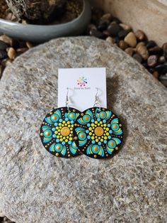 a pair of earrings sitting on top of a rock