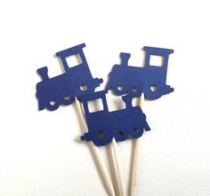 blue train cupcake toppers with wooden sticks in the shape of two trains on them