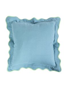 a light blue pillow with scalloped edges on a white background and green trim