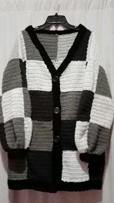 a black and white sweater hanging on a hanger