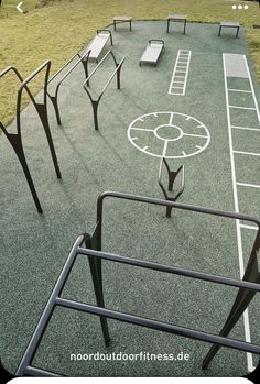 an empty basketball court with benches on the side and grass in the backgroud