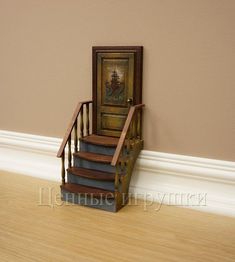 a stair case sitting on top of a hard wood floor next to a wooden door