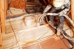 a man is working on the floor in his attic with wood framing and tools around him