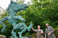 two men are standing next to a statue