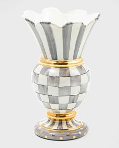 a white and black vase with gold accents