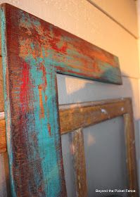 an old wooden frame hanging on the wall with paint peeling off it's sides