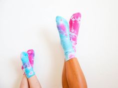 the legs and feet of a woman with pink and blue tie - dyed socks on