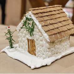 a small house made out of rocks on top of a white cloth covered tablecloth