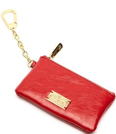 a red purse with a gold keychain hanging from it's front pocket