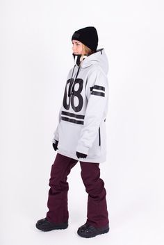 a young man standing in front of a white background wearing a snowboard jacket with the number 86 on it