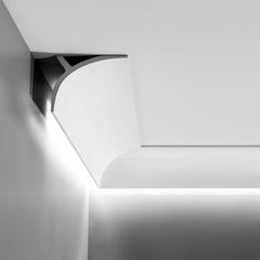 the corner of a room with a light on it and a white wall in the background