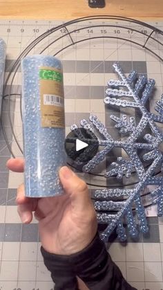 someone is making a snowflake out of plastic wrapper and some glitters